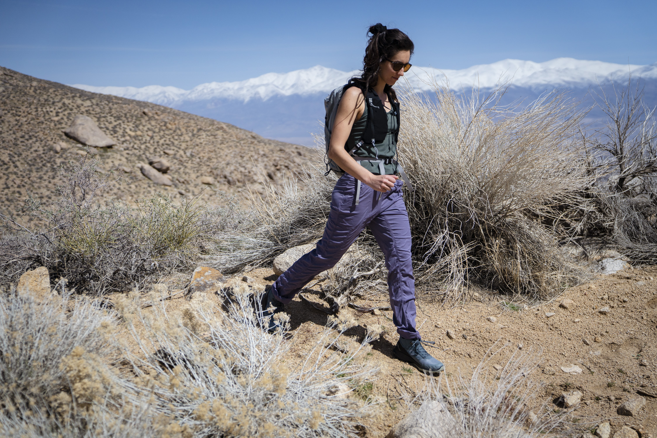 Close up of hiking pants on a trail showing the fit and articulation at the knee.