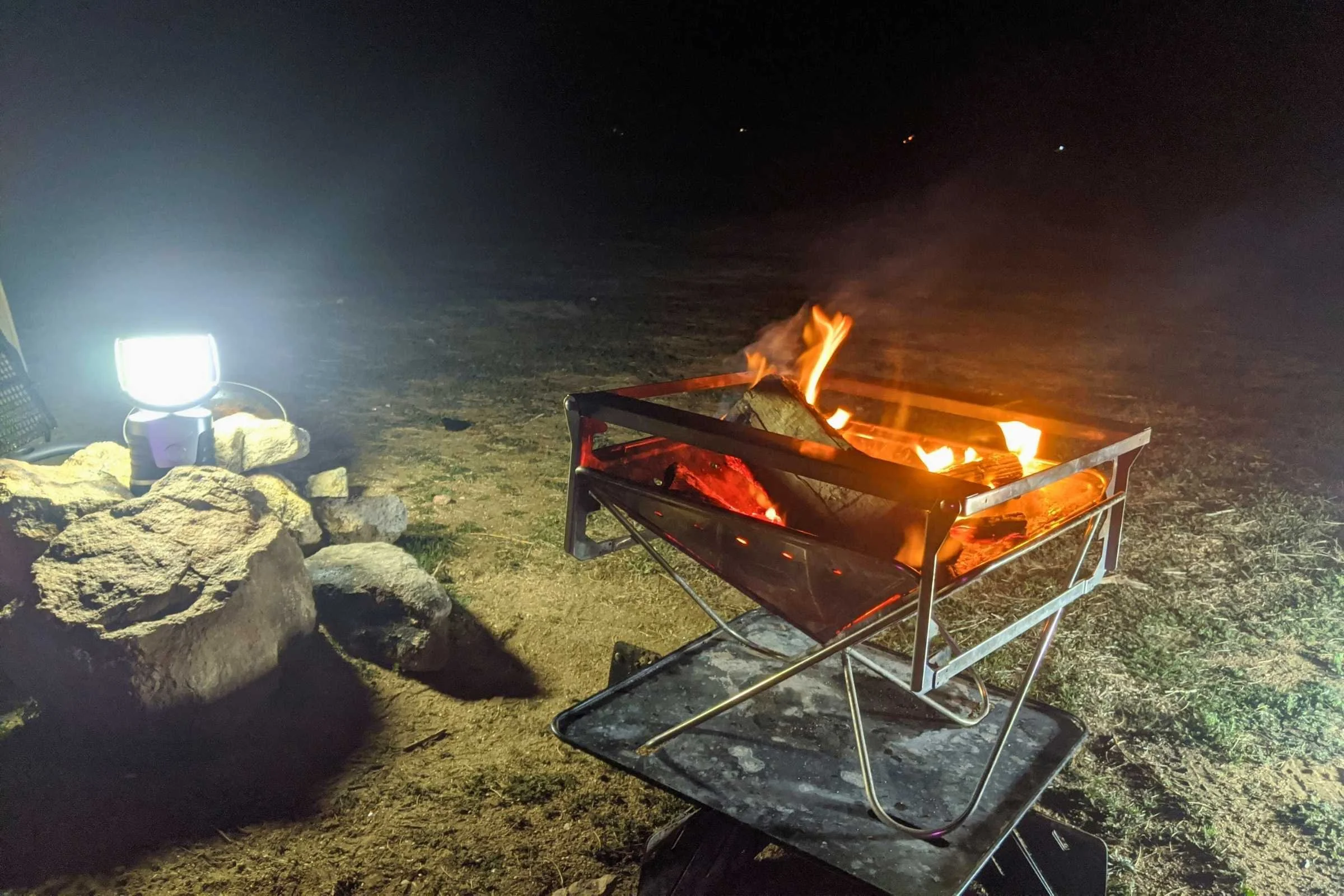 The UST 60-Day DURO lantern casting a wide, bright light across a dark campsite.