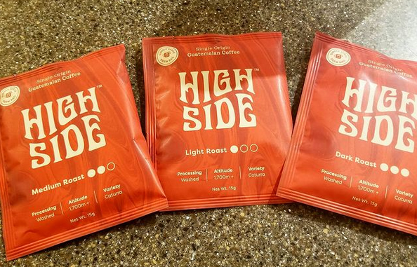 High Side Coffee packets and branding displayed on a wooden surface.