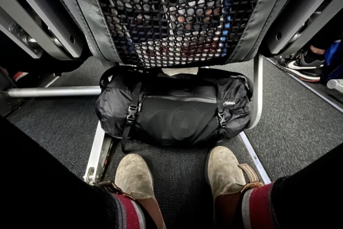 A small duffel bag fitting under an airplane seat as a carry-on.