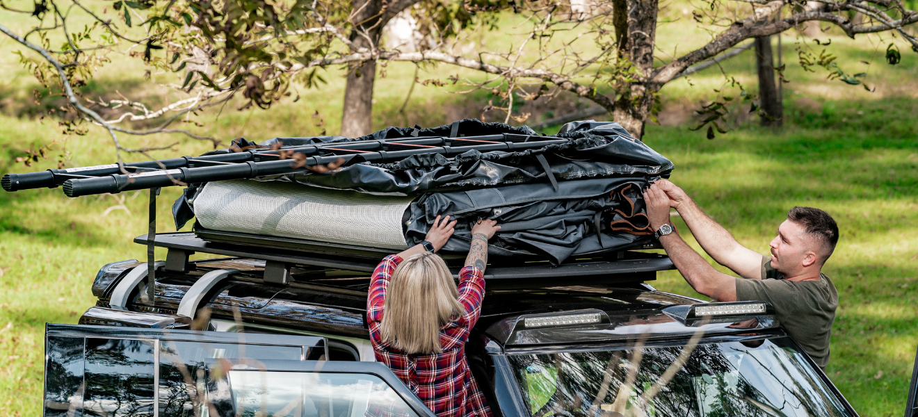 A rooftop tent with a large fabric annex extension reaching down to the ground.