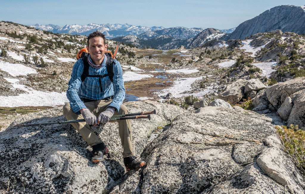 Andrew Skurka standing on a mountain peak with ultralight gear.