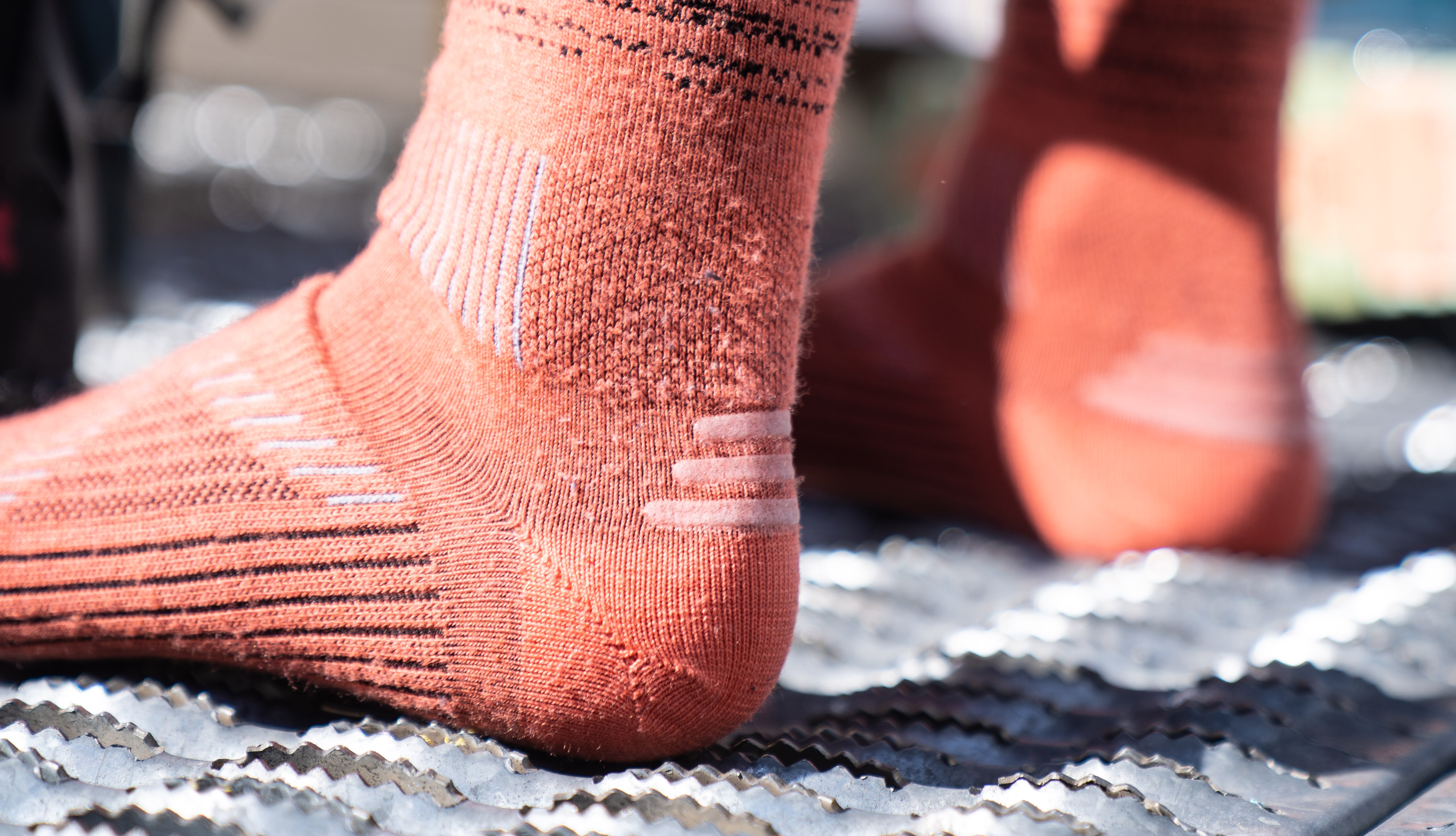 Testers holding and comparing the texture of synthetic and natural wool ski socks.