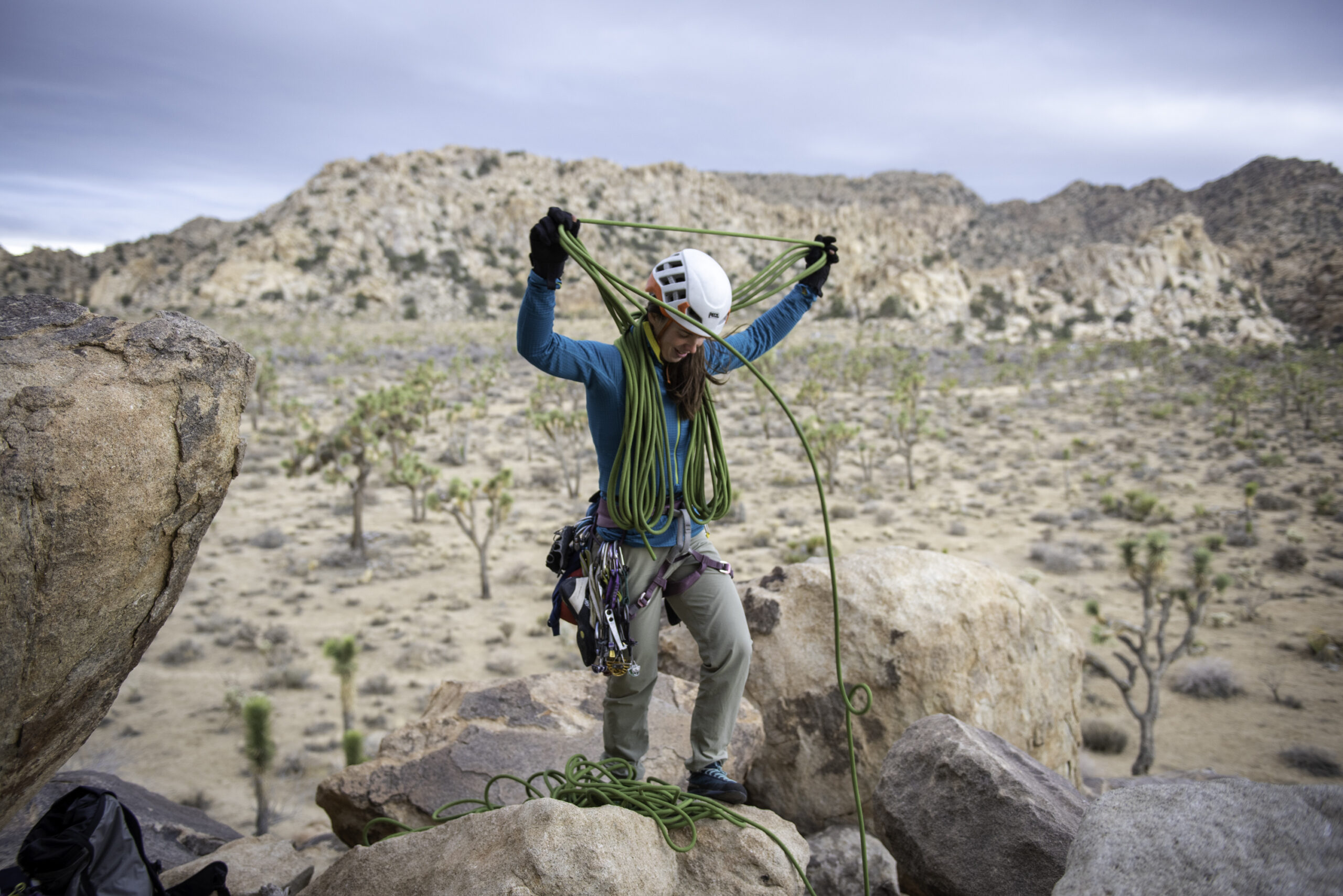 A hiker wearing Ferrosi pants handles a climbing rope outdoors.