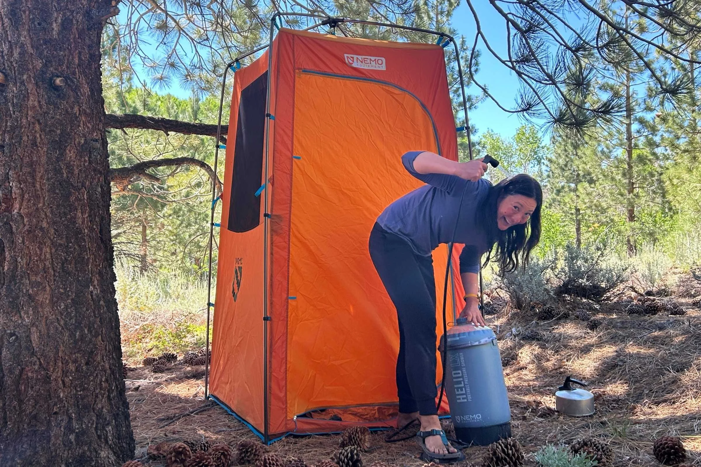 The Nemo Helio LX pressurized camp shower featuring its signature black tank and foot pump.