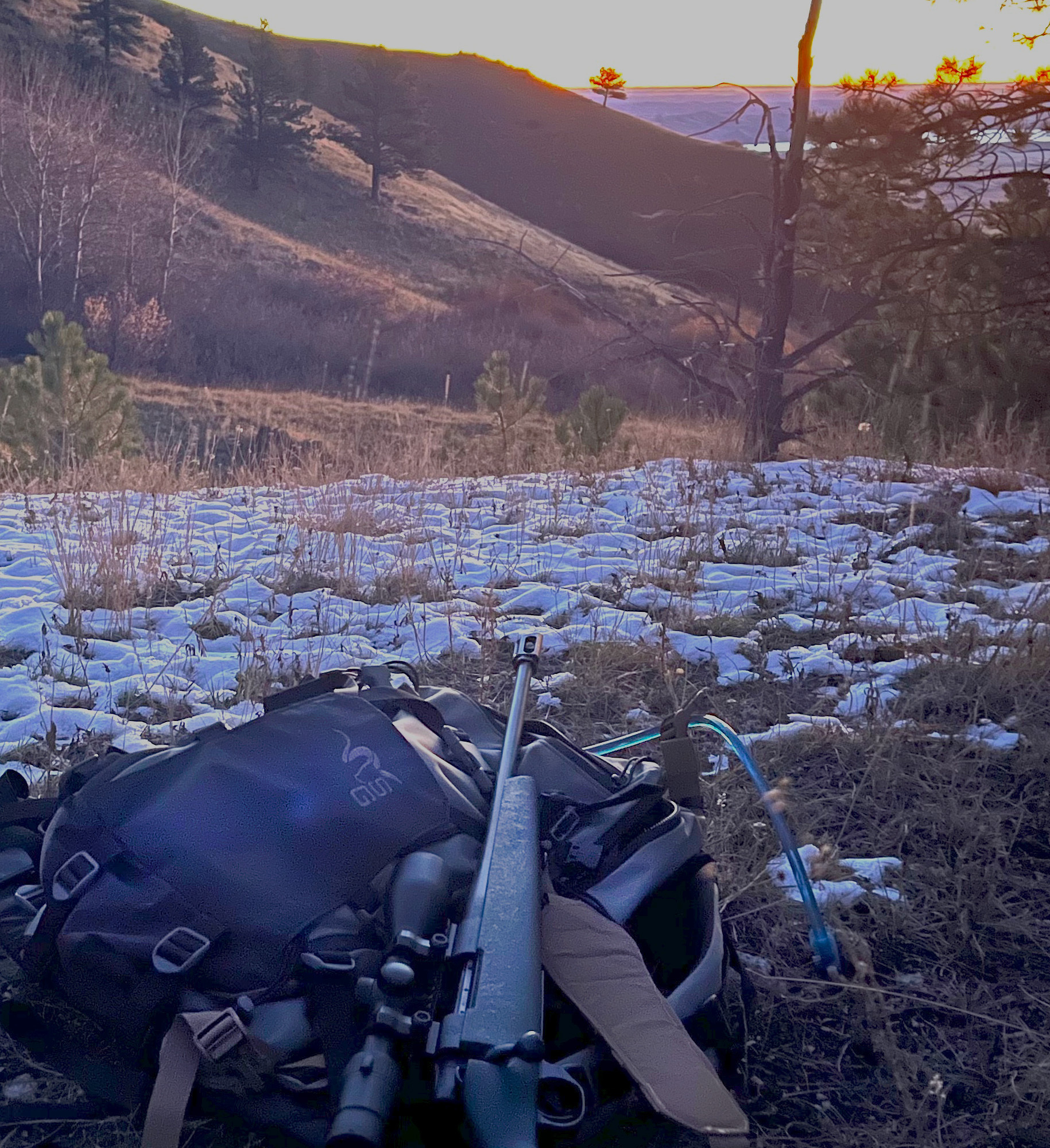 A female hunter resting with a compact Stone Glacier Avail daypack.