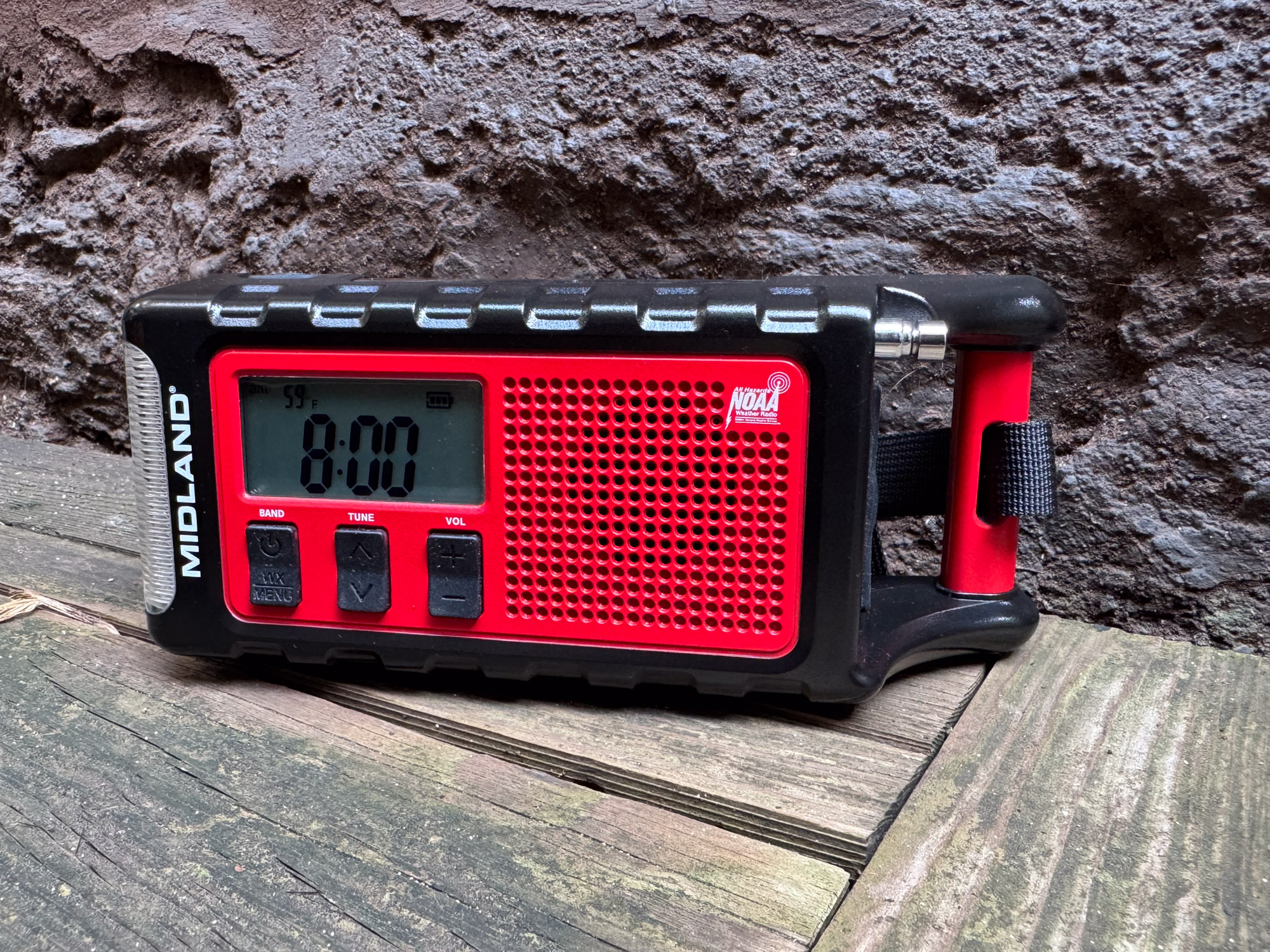 The Midland ER310PRO radio sitting on a wooden bench outdoors.