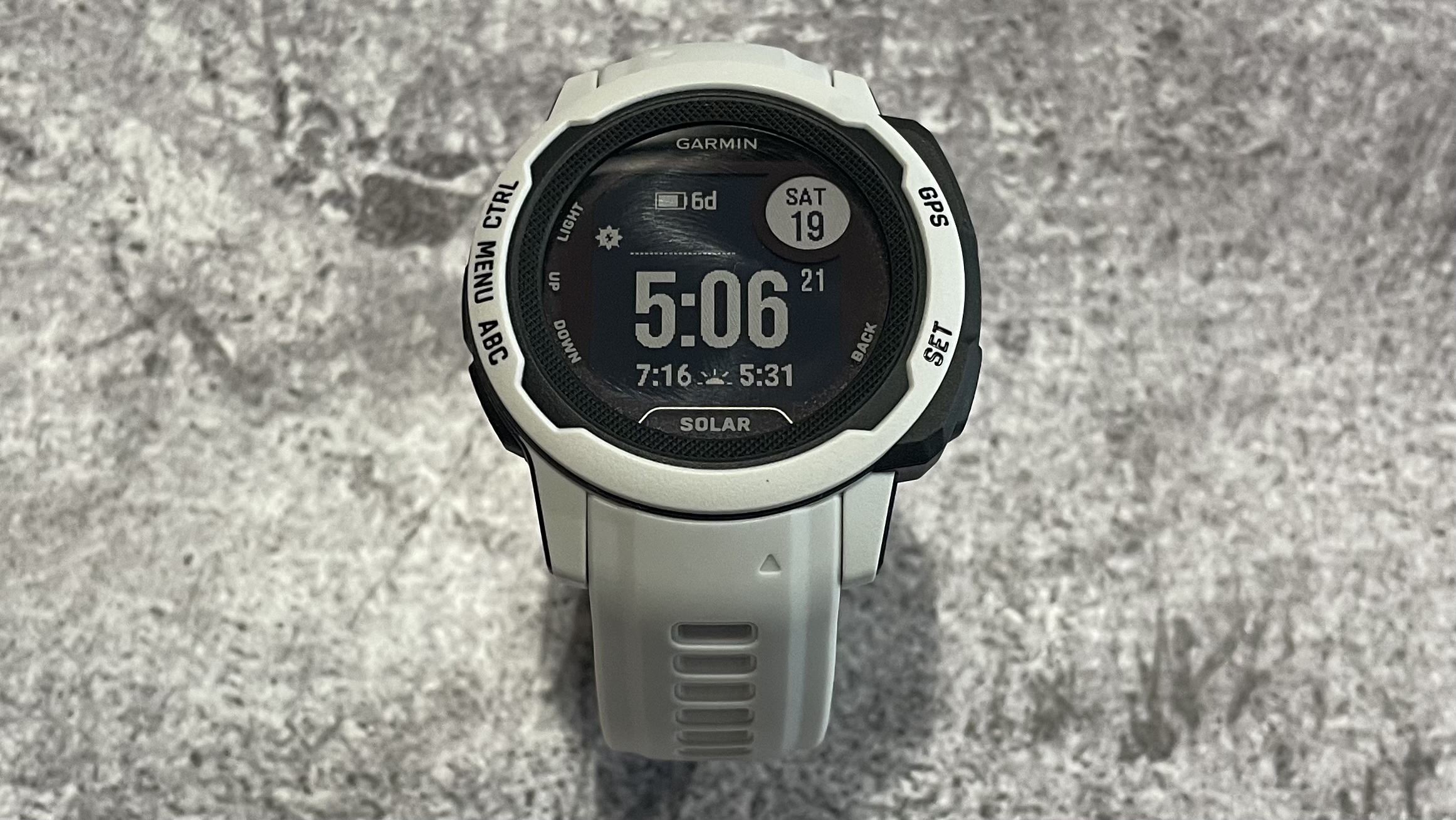 Close-up of the Garmin Instinct 2 being worn on a wrist outdoors.