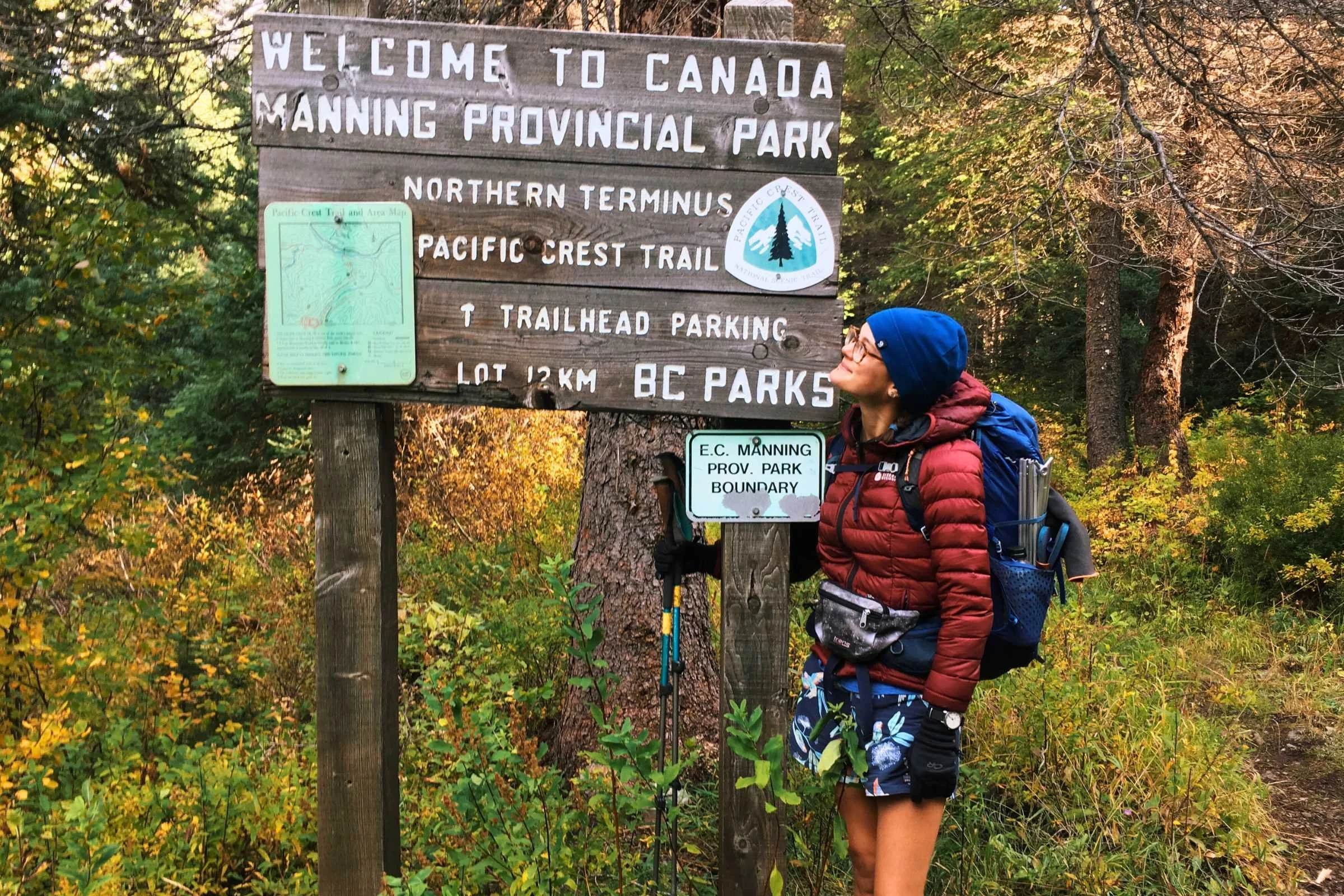 Thru-hiker 'Snacks' celebrating at the Canadian border monument in Patagonia Baggies.