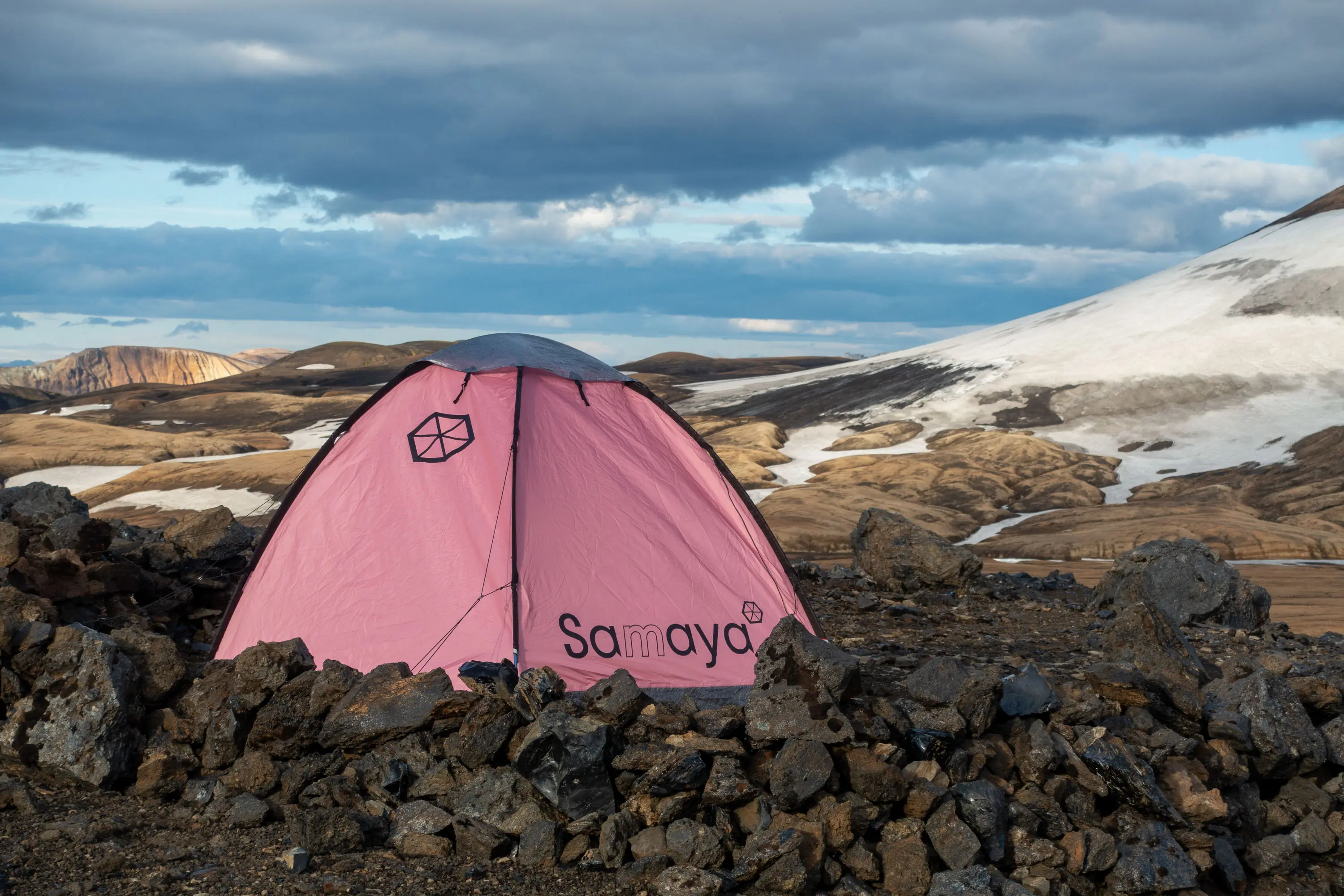 A blue Samaya 2.5 single-wall tent set up on a rocky, snowy ridge in Iceland.