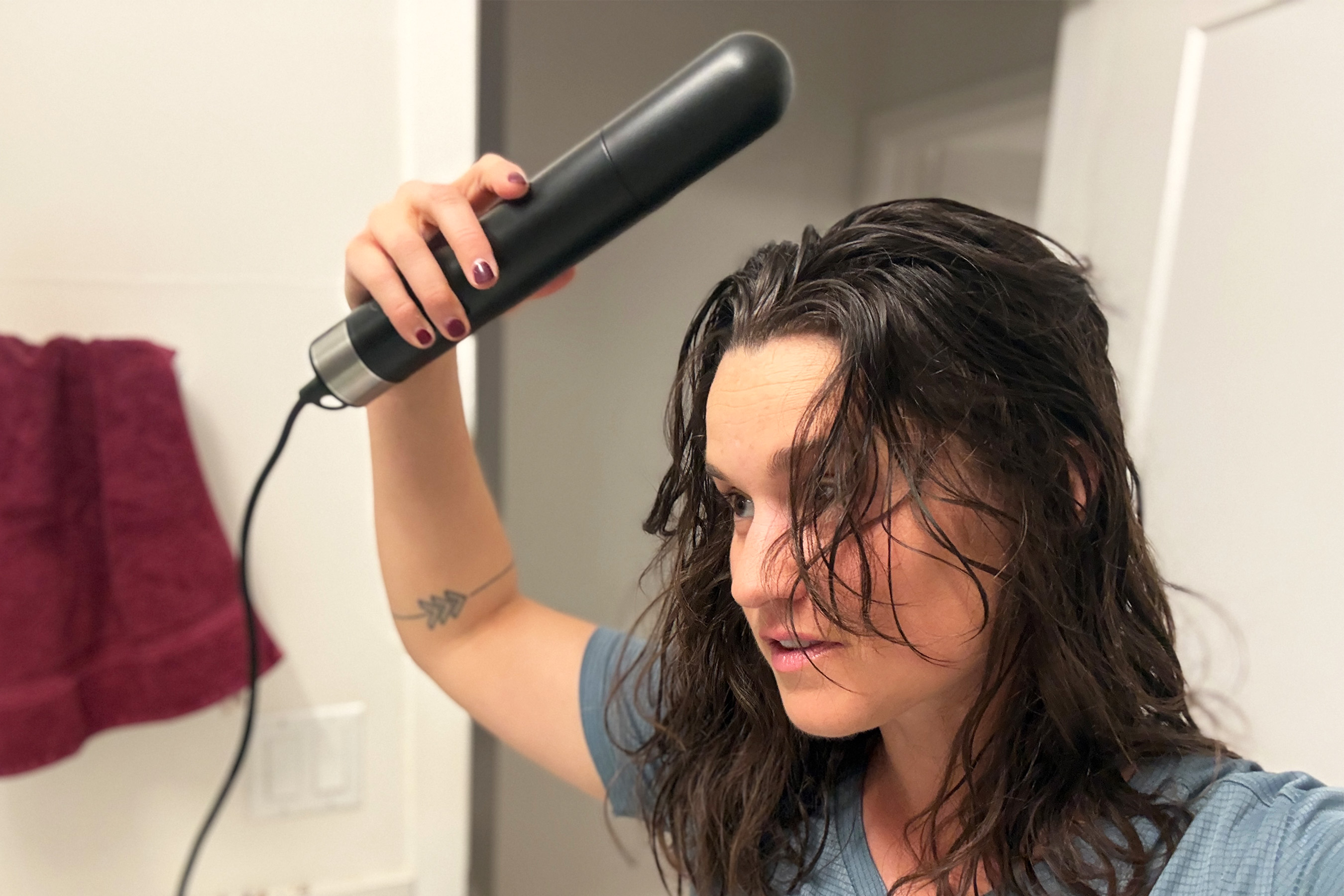 A close-up of the Hedgehog GO being used with the hair dryer attachment on a person's hair.