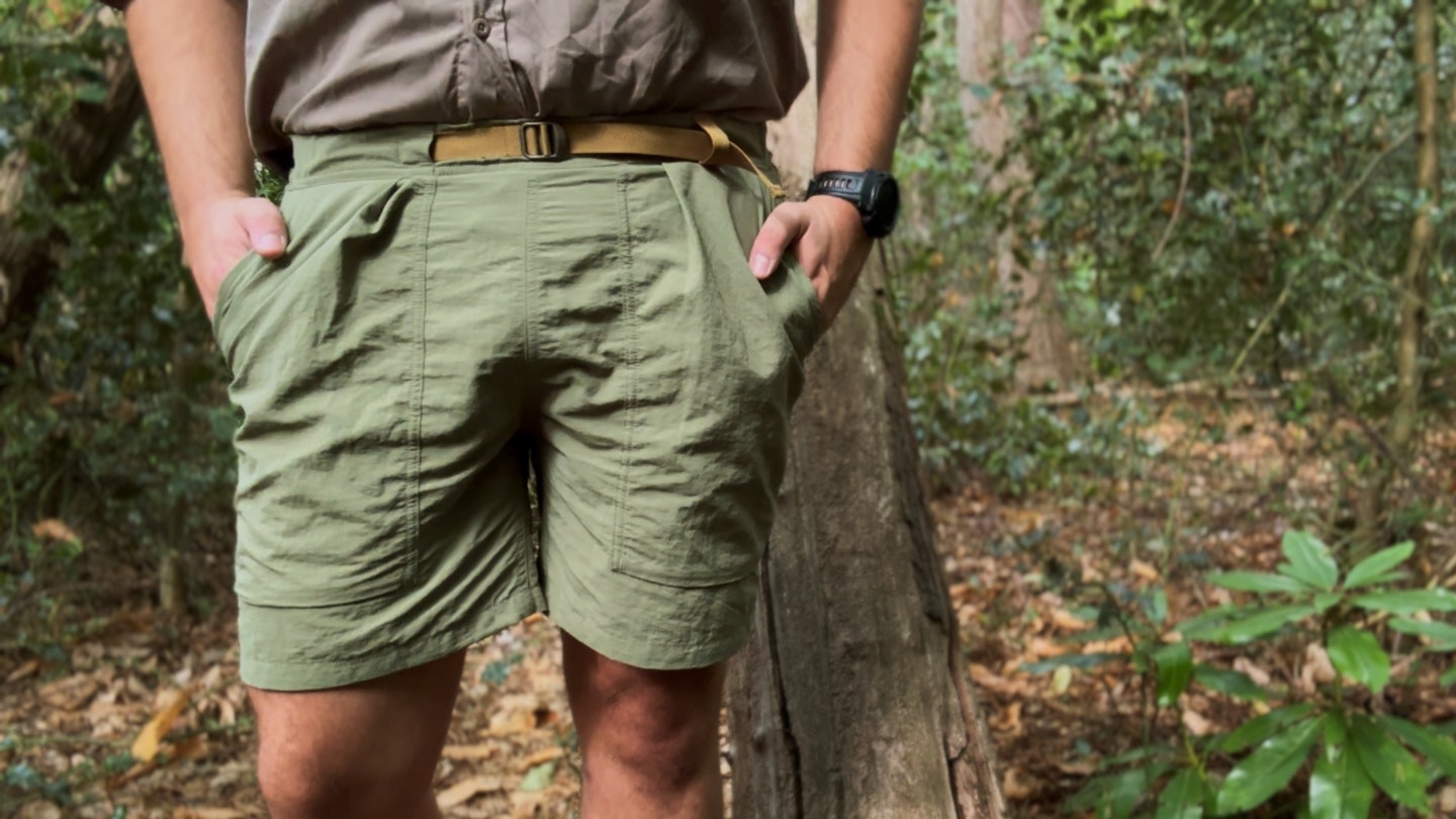Close-up view of the waistband and fabric texture of a pair of utility hiking shorts.