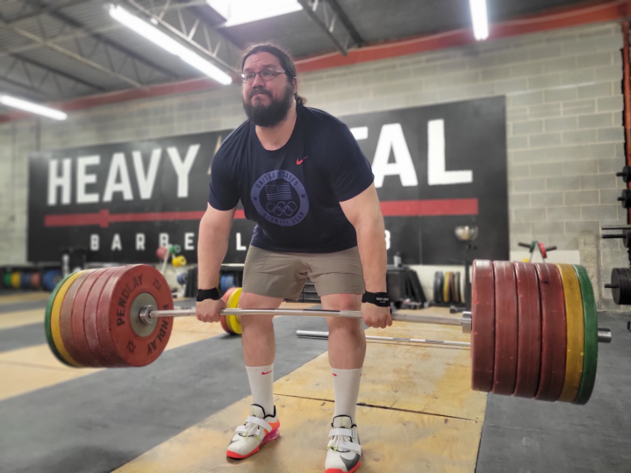 Athlete performing a deadlift with a barbell while wearing training shorts