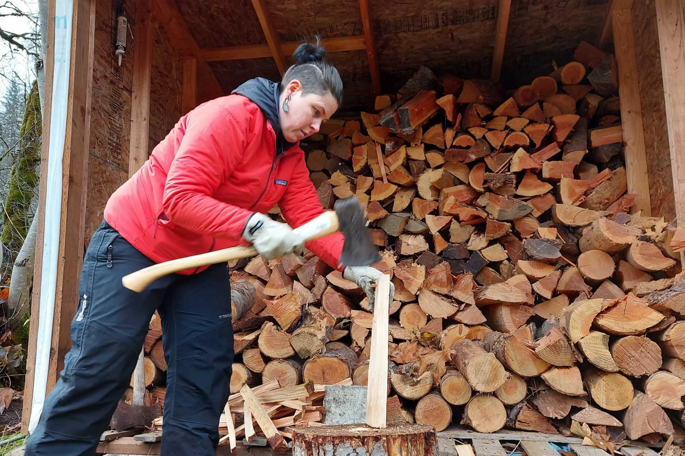 A person chopping wood while wearing a breathable Patagonia Nano-Air jacket