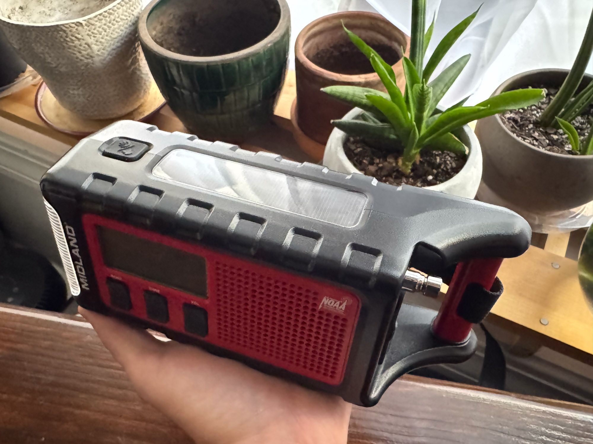 The author holds the ER310PRO radio showing the top-mounted solar panel.