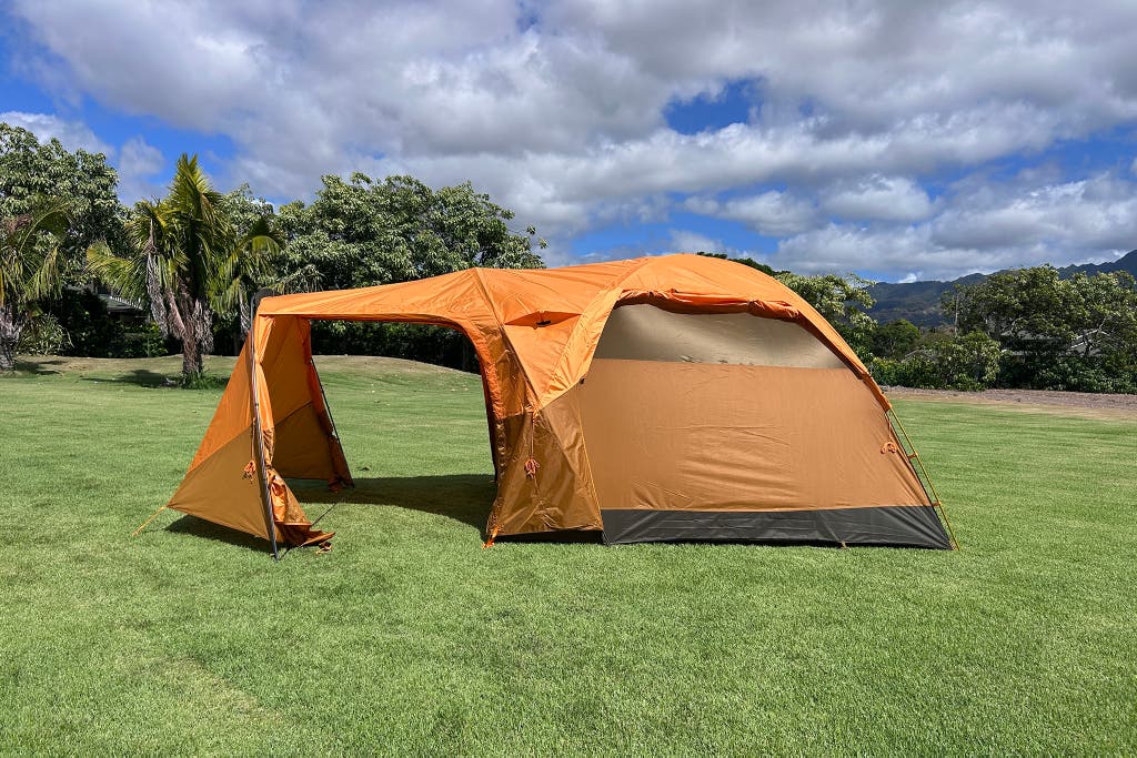 The North Face Wawona 6 tent with its distinctive large front porch area in a forest setting.