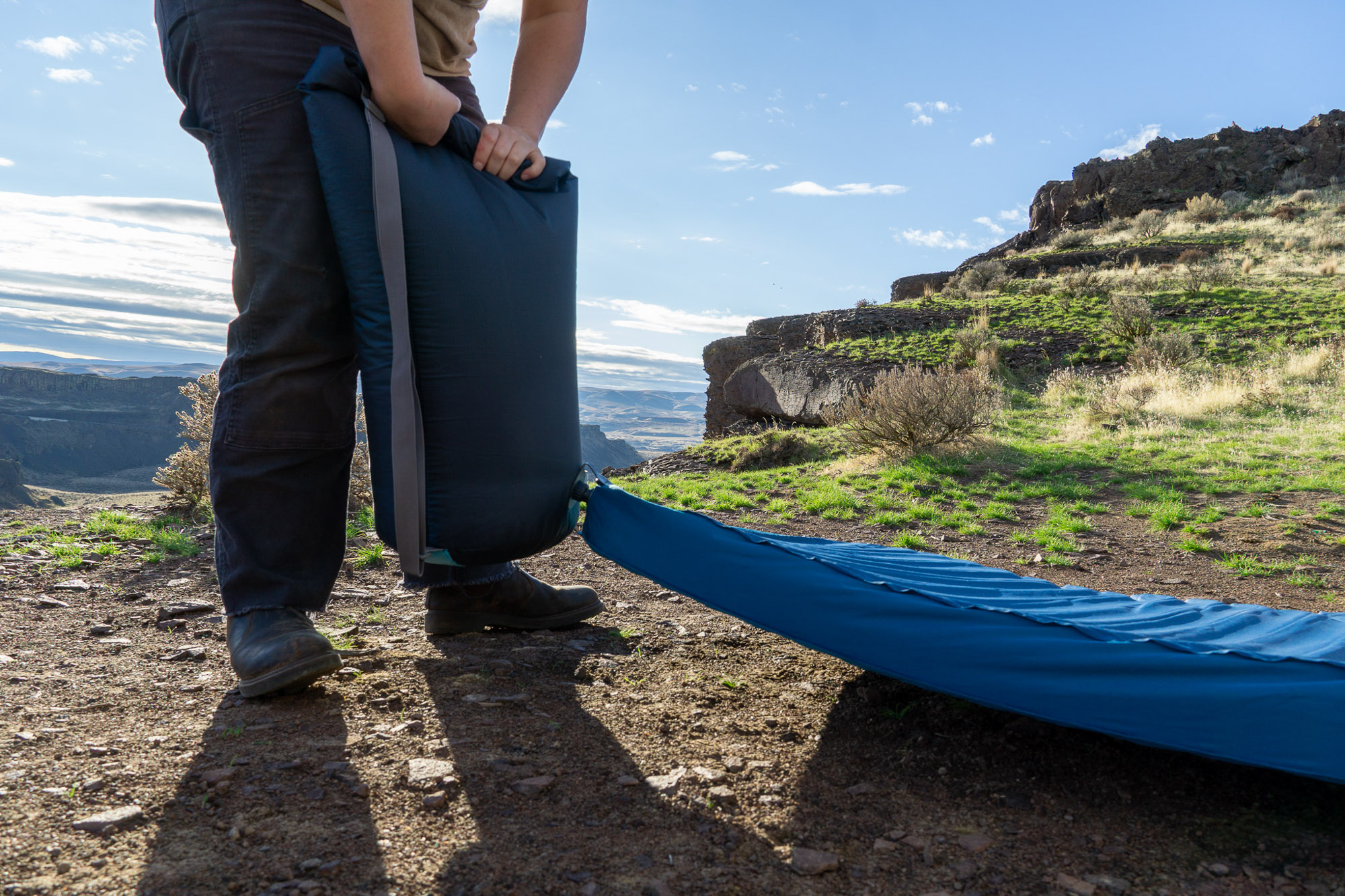 The author inflating the mattress in a natural outdoor setting in eastern Washington.