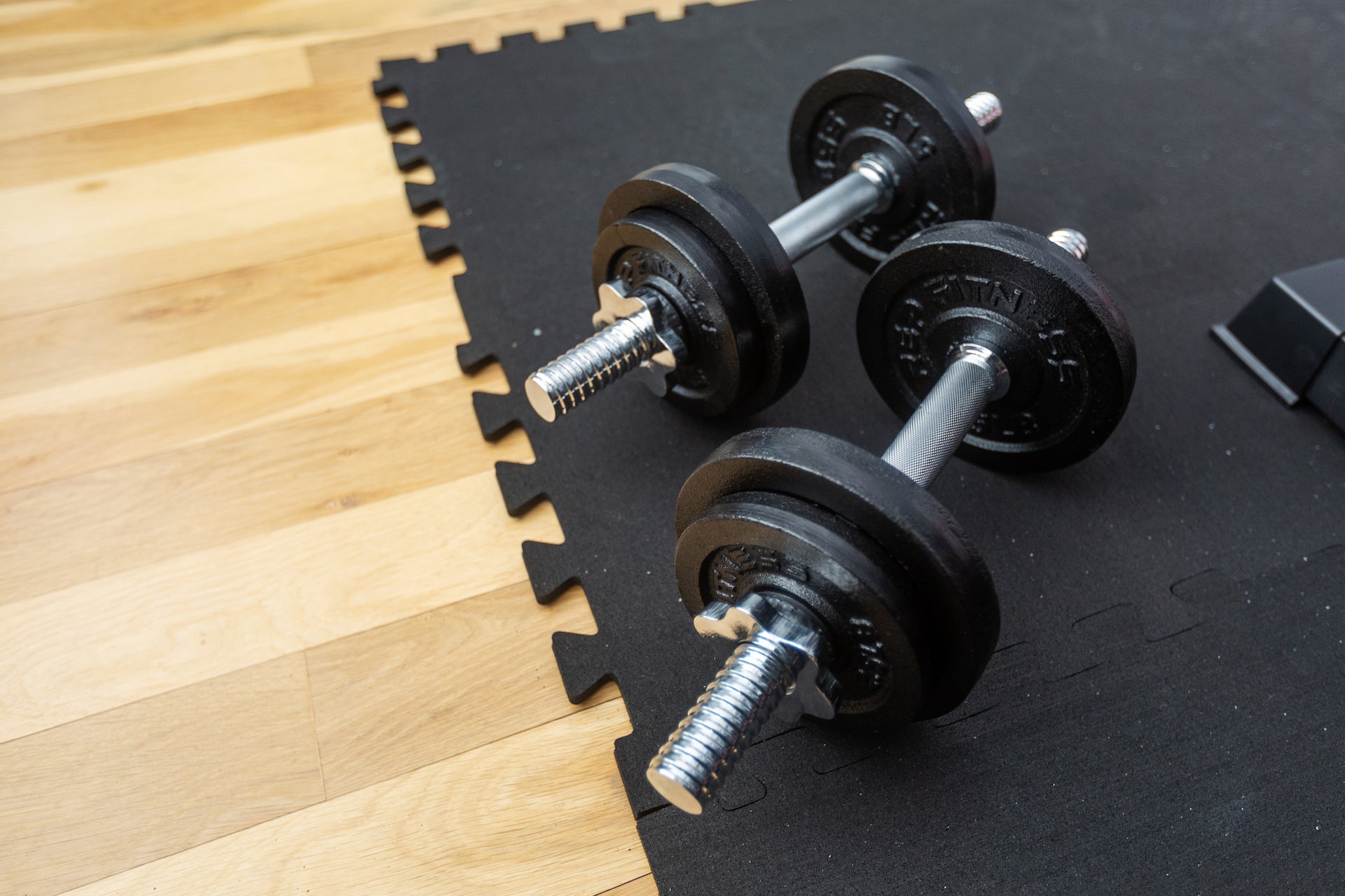 Interlocking rubber floor tiles with a dumbbell.
