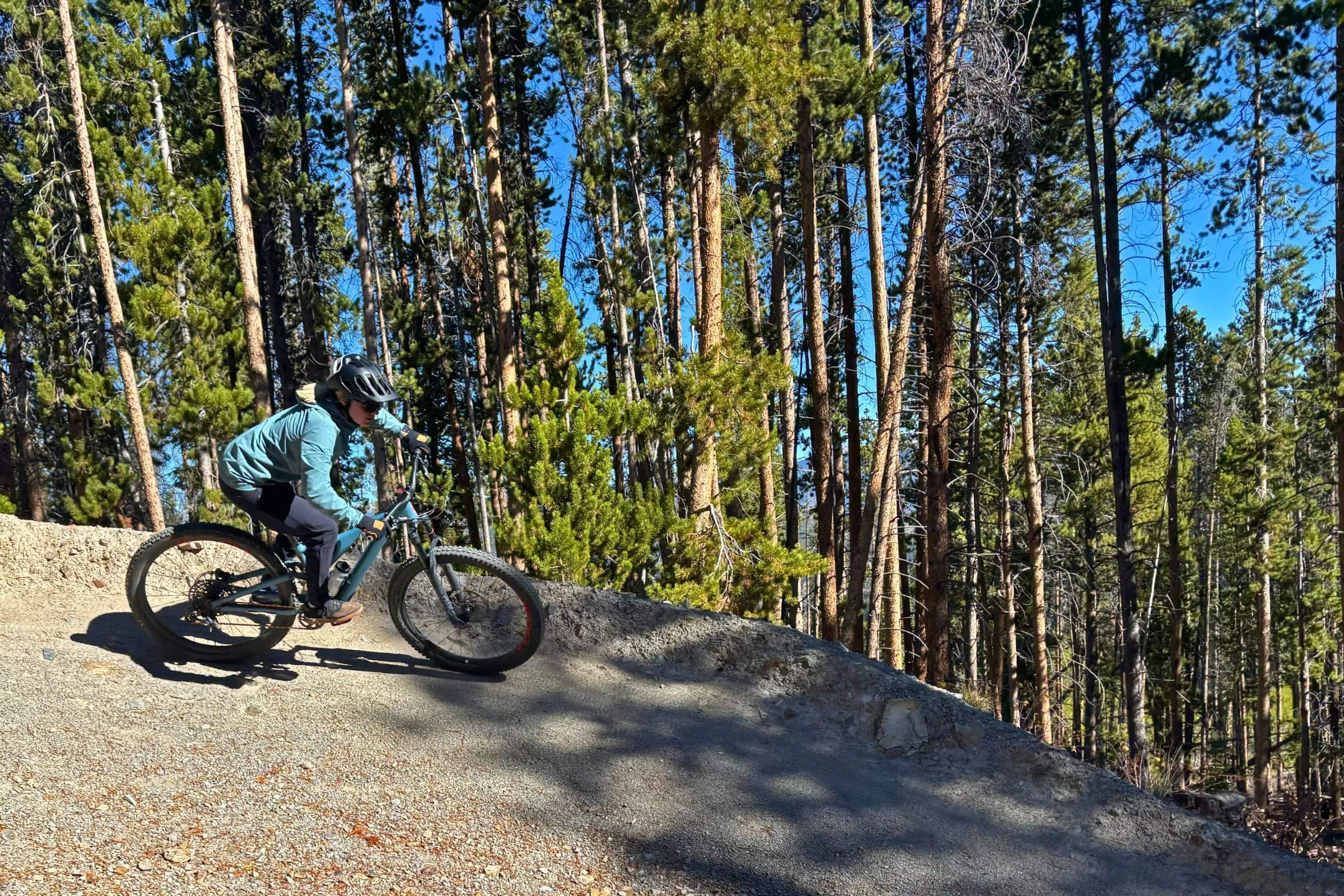 The author riding a mountain bike on a trail while wearing the Outdoor Research Freewheel jacket.