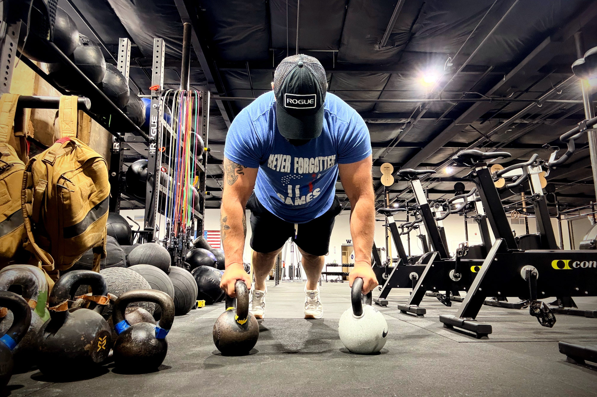 Close-up of Nike Rubber Coated Kettlebell being used for pushups on a floor.