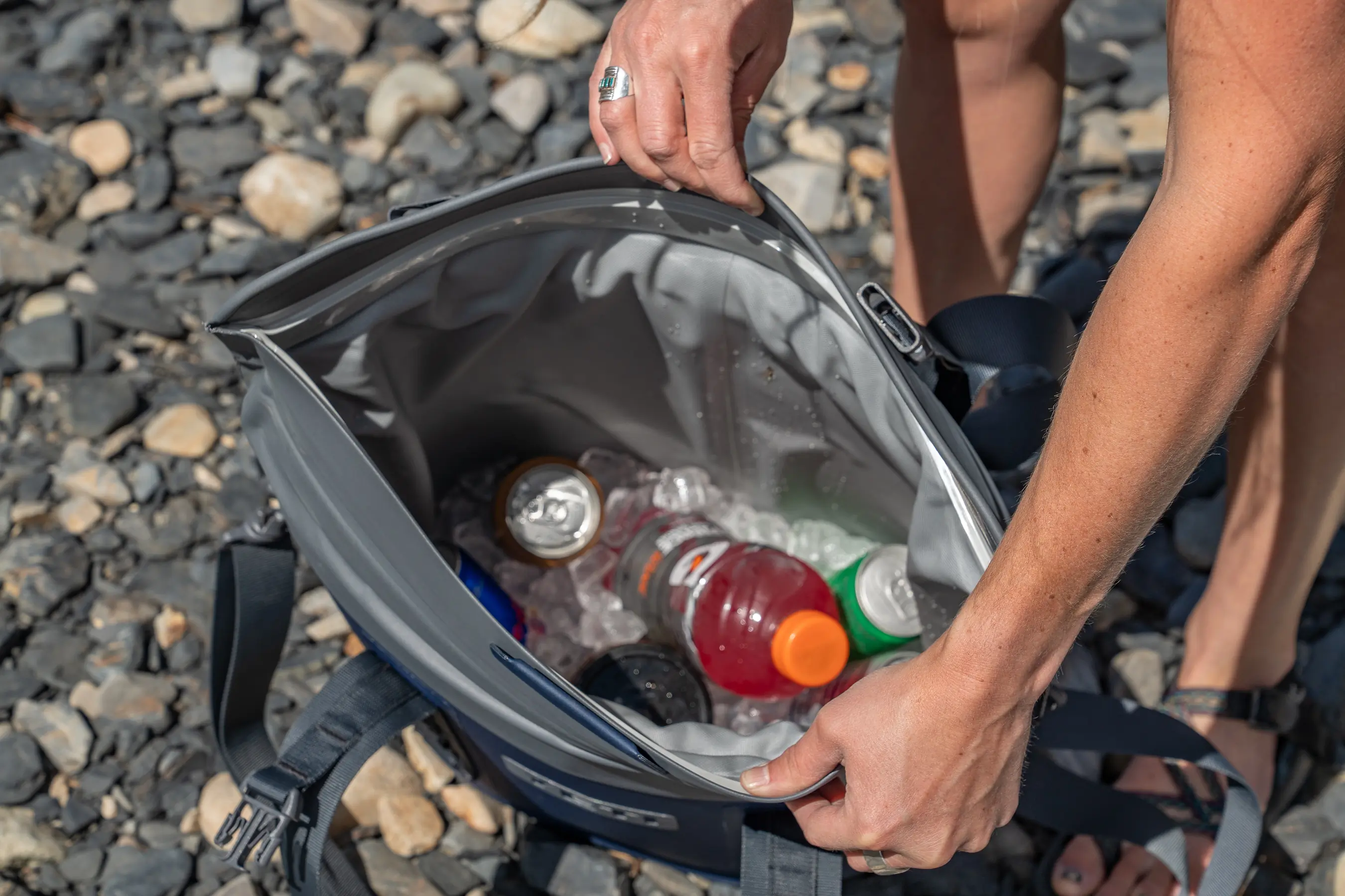 An interior view of a soft cooler tote showing bottles and cans submerged in plenty of ice.