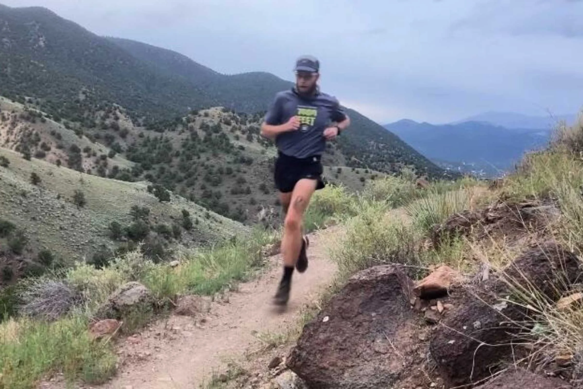 A runner navigating a technical dirt trail wearing Tifosi Veloce photochromic sunglasses.