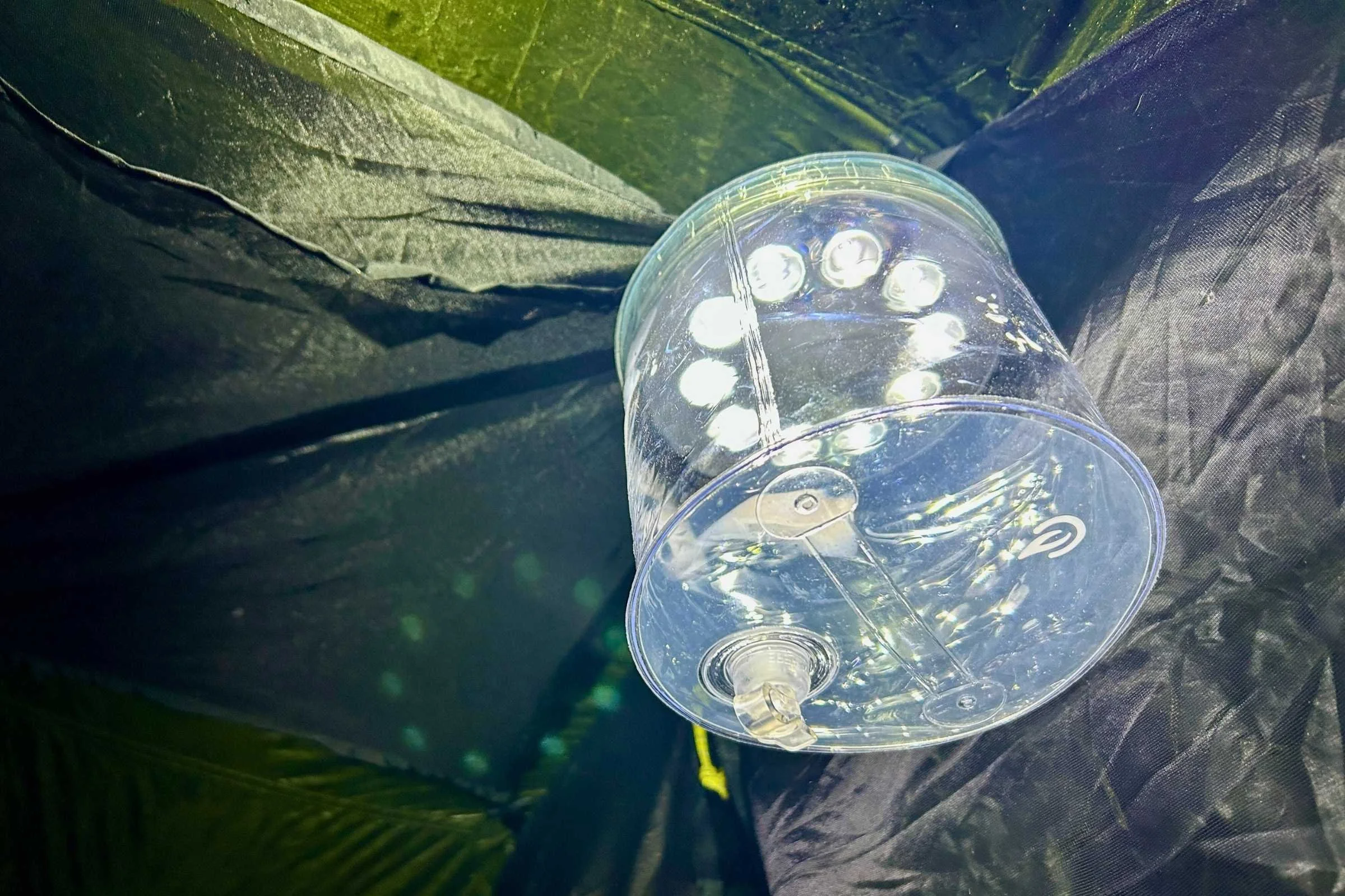 A translucent inflatable BioLite Luci lantern hanging from the ceiling of a tent.