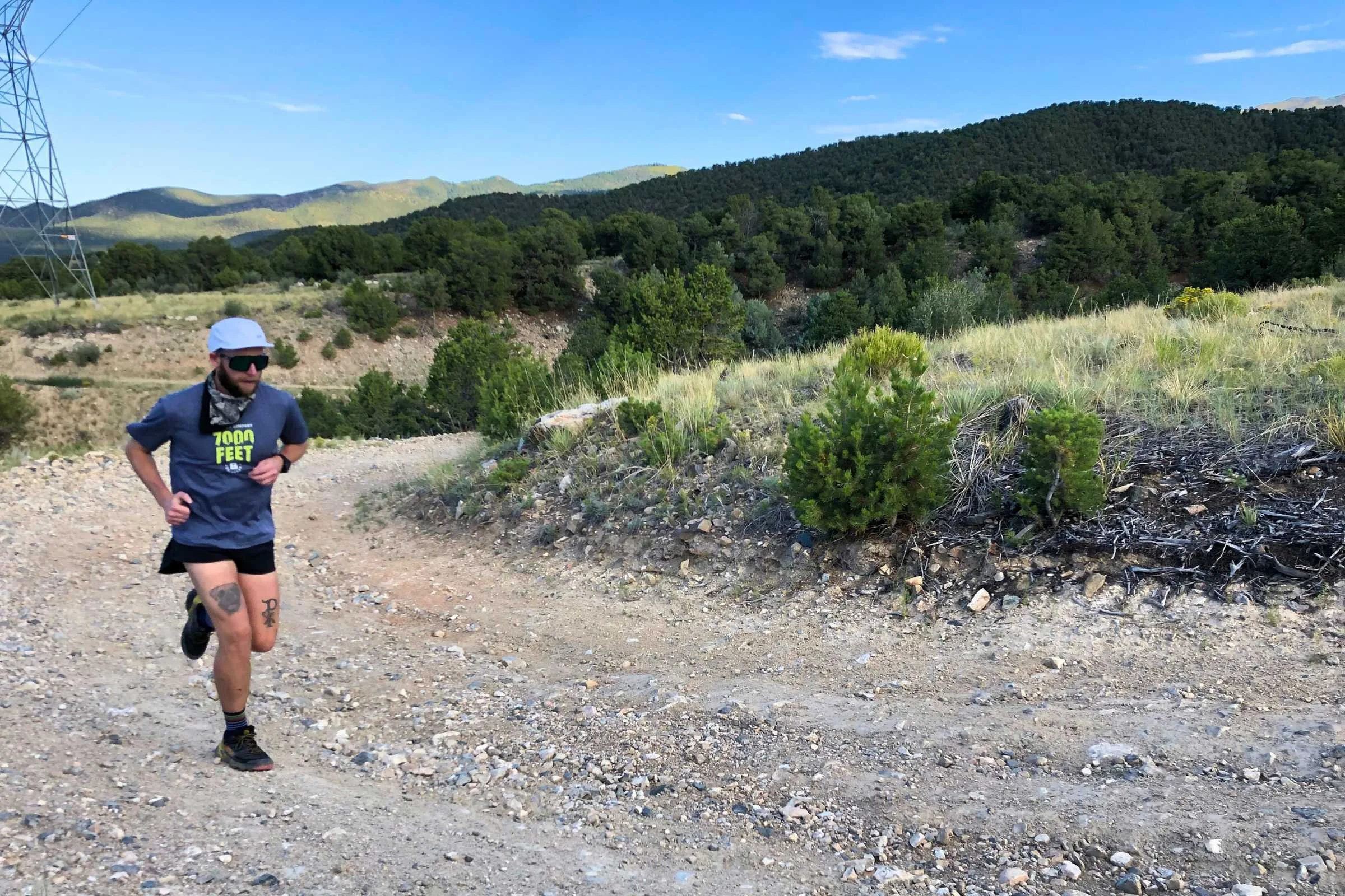 A runner wearing large Oakley Sutro shield sunglasses on a bright dirt road.