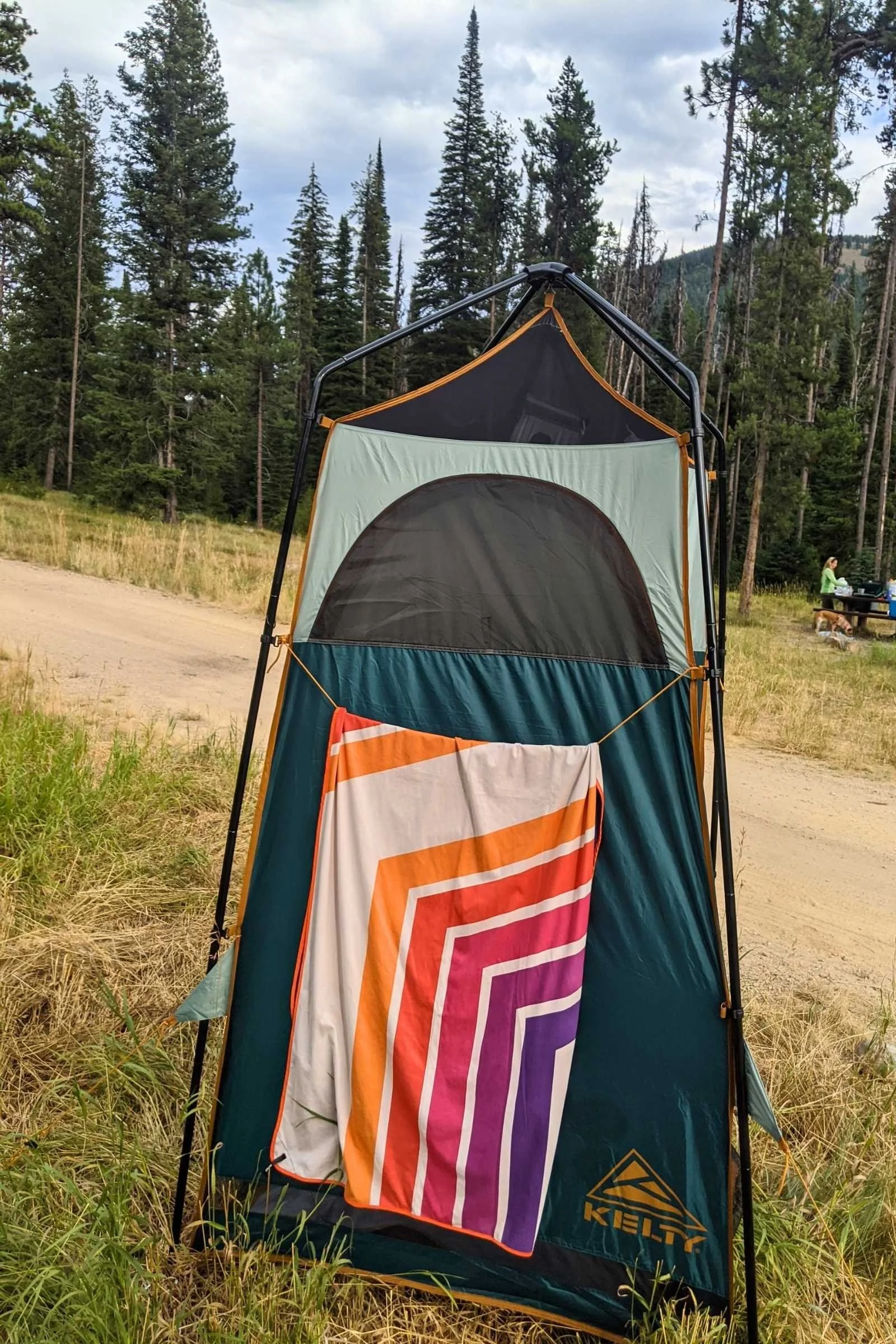 A Kelty H2Go shower tent standing in a scenic, remote mountain campground.