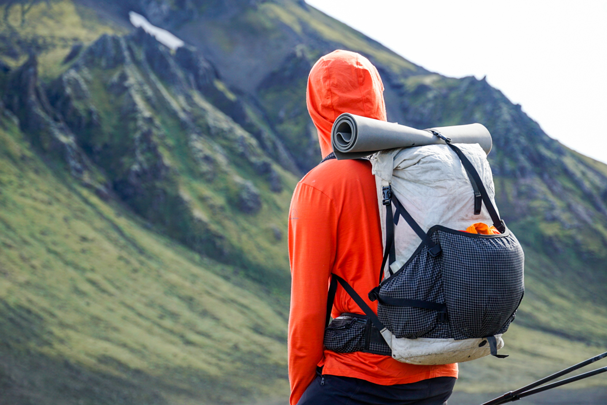 A woman wearing a Ridge Merino hoodie looking out over a misty Icelandic landscape.