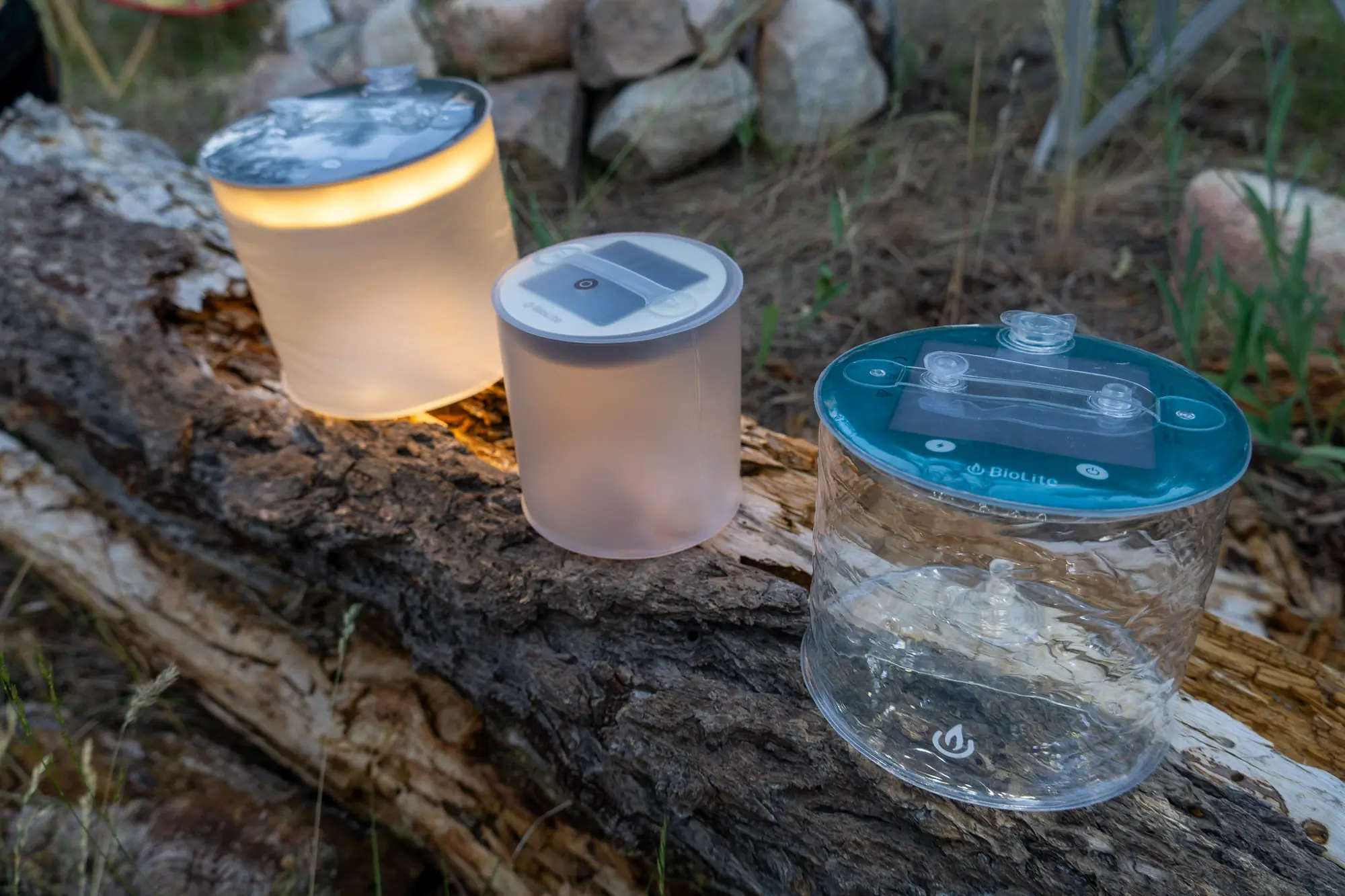 A collection of various camping lanterns of different sizes and shapes being compared outdoors.