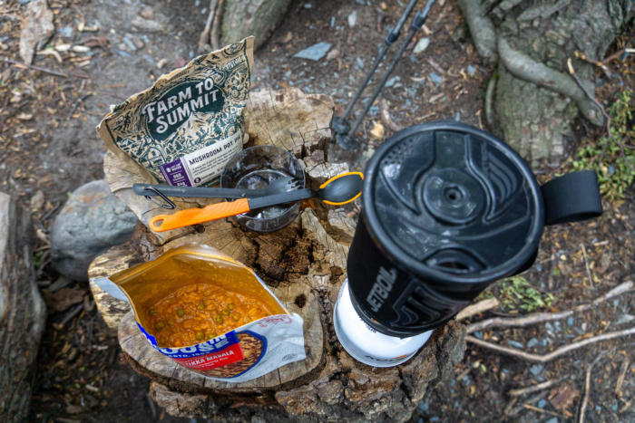 Macro shot of a rehydrated backpacking meal inside its original silver foil pouch.