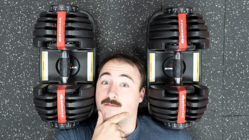 Pair of BowFlex SelectTech 552 adjustable dumbbells sitting on their custom storage stands.