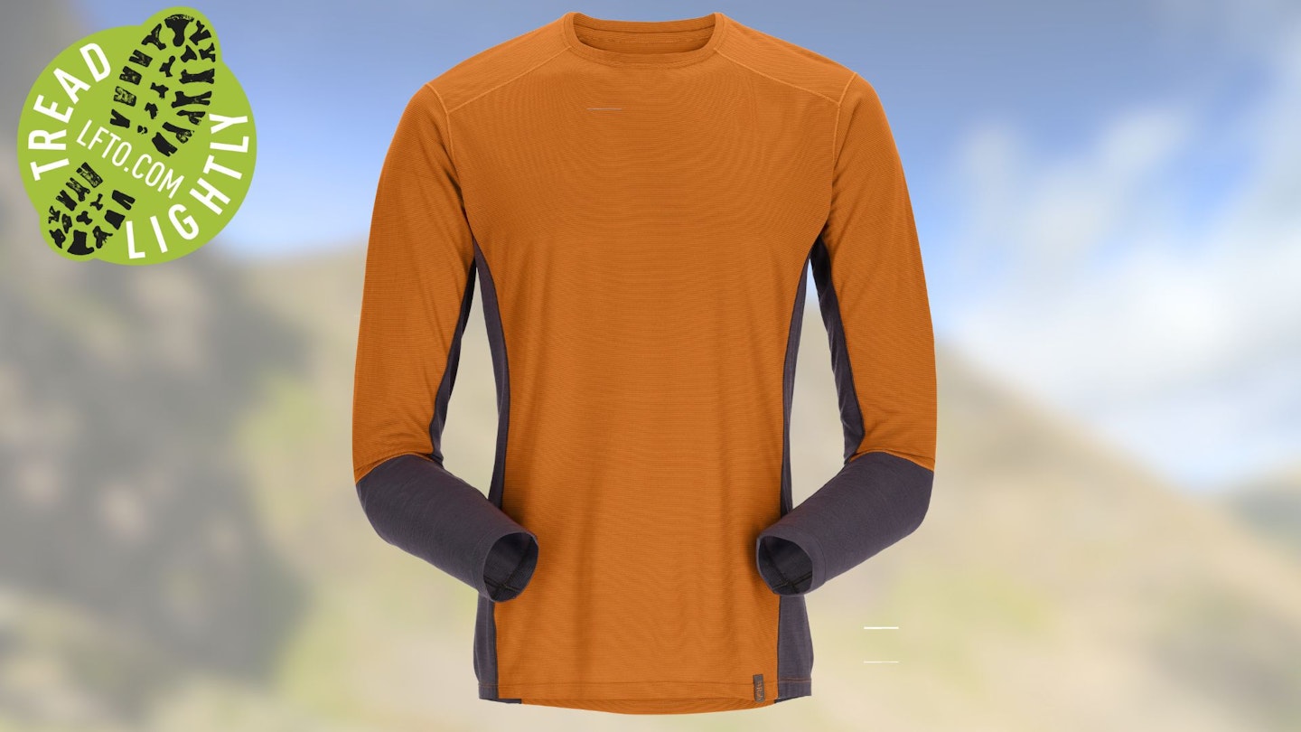 A hiker with a backpack wearing a Rab Syncrino base layer in a rocky mountain environment.