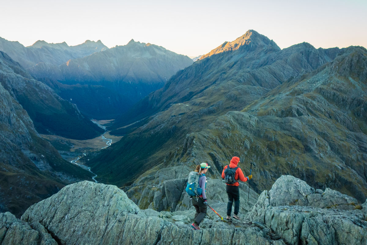 A runner on a high mountain ridgeline wearing wind-resistant pants.