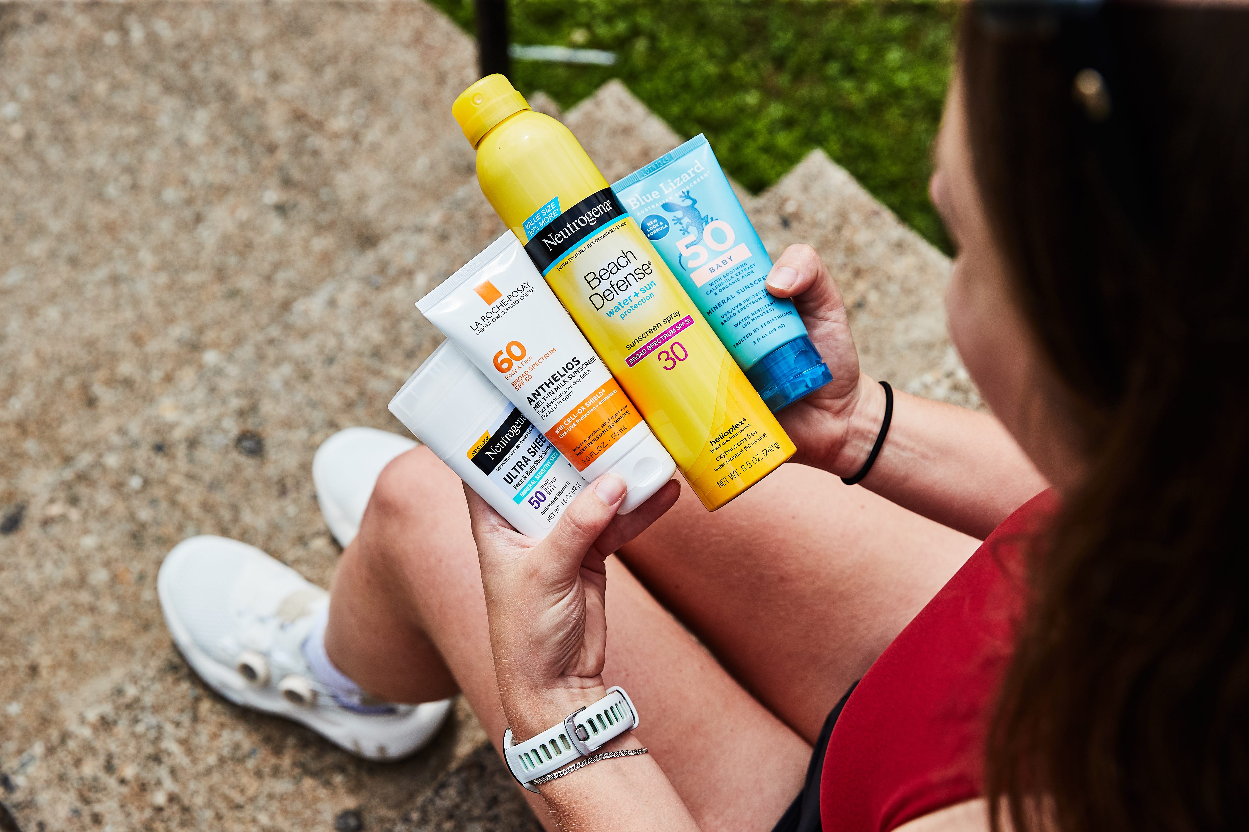 A runner applying sunscreen to their arm before a workout.
