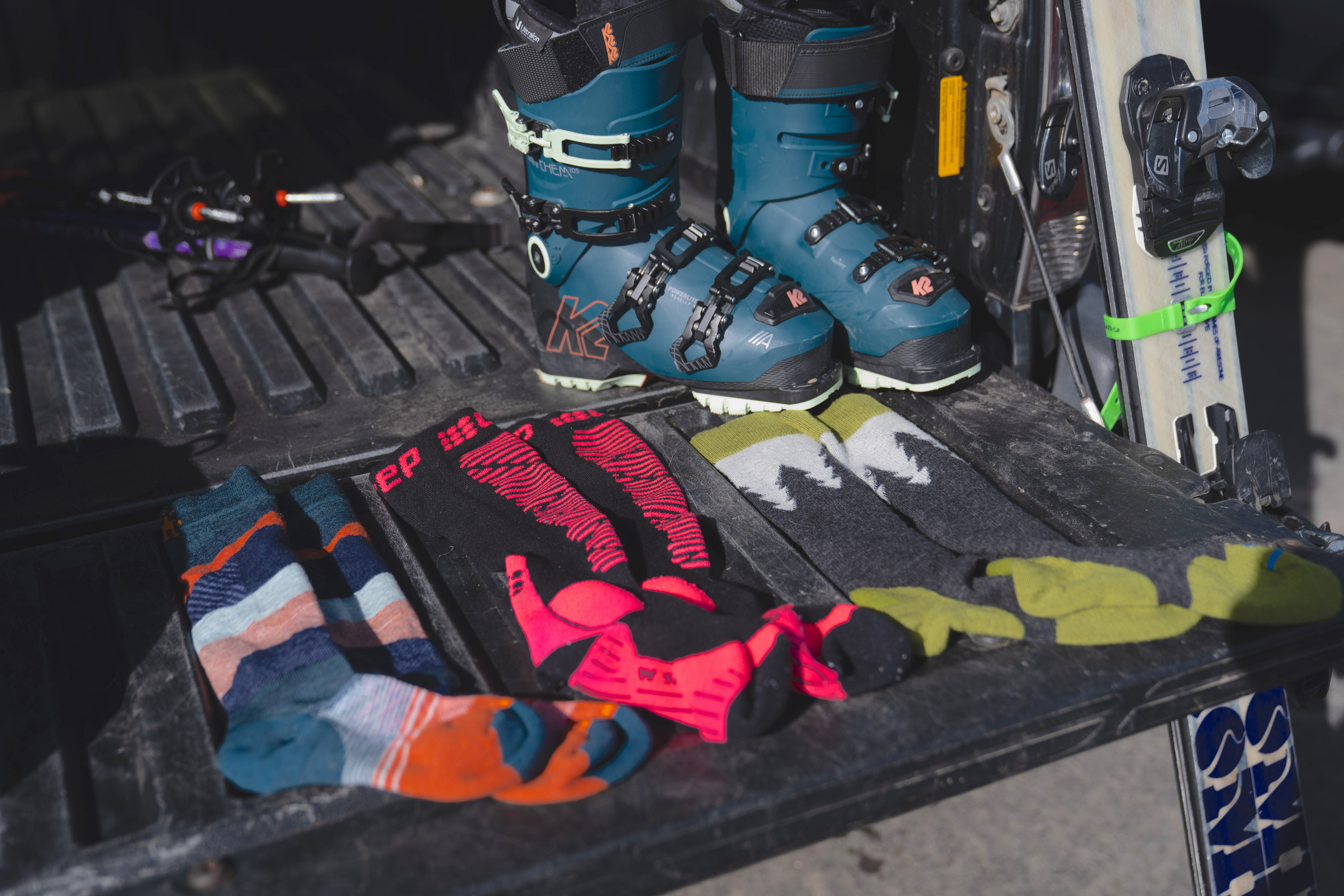 A tester sliding their foot into a technical ski boot while wearing a thin performance sock.