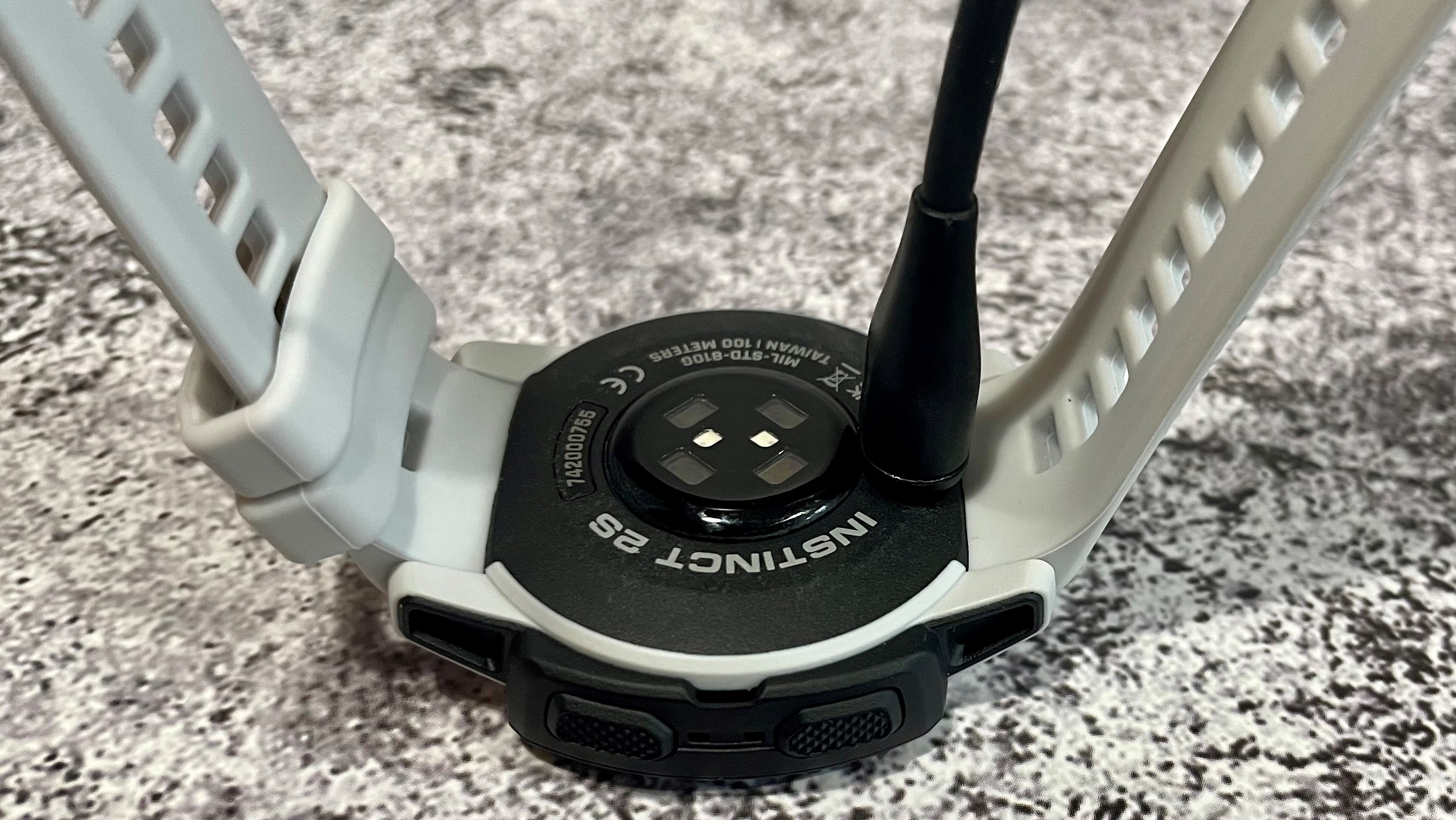 Rear view of the Garmin Instinct 2 showing the sensor array and proprietary charging port.