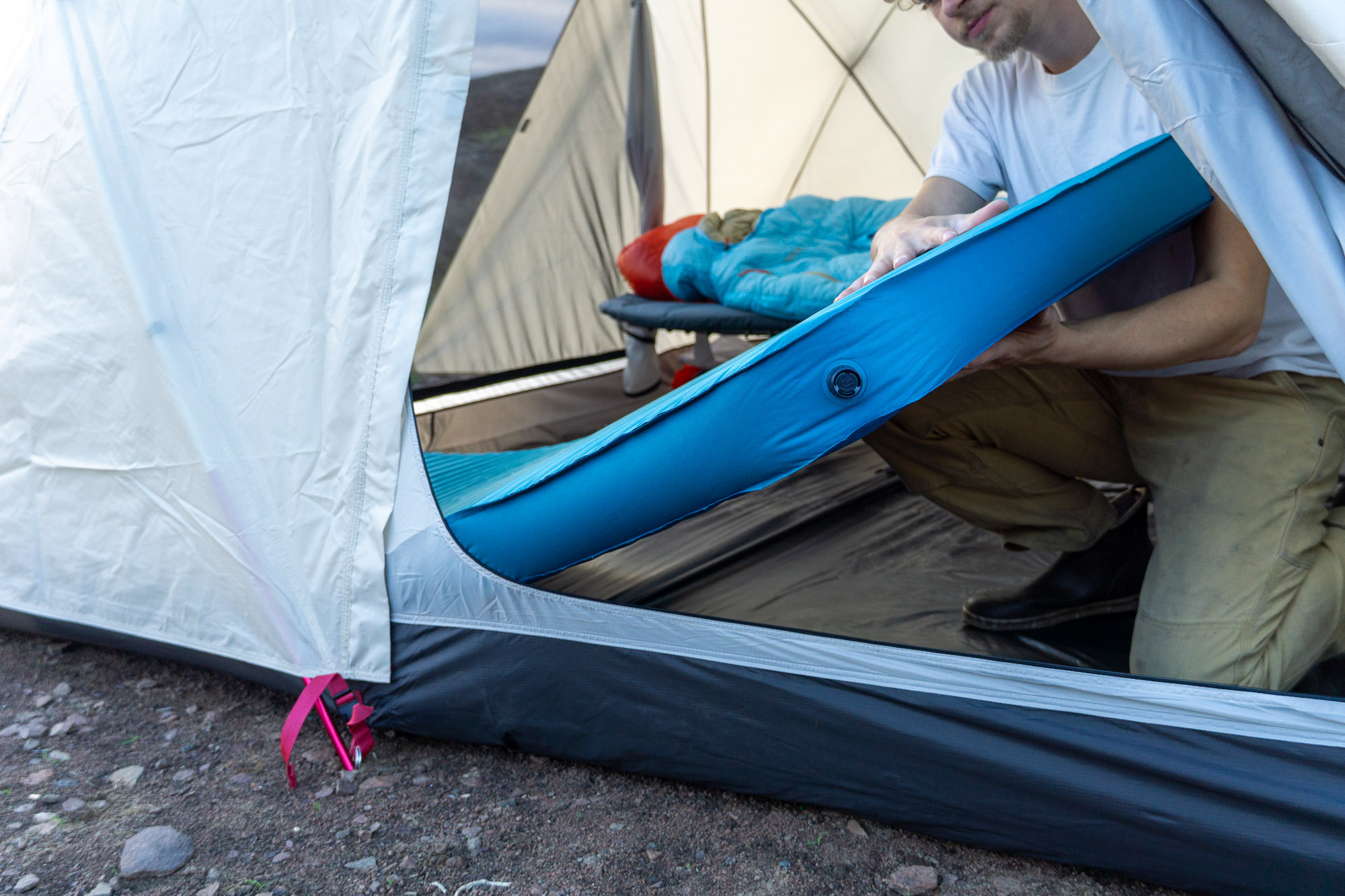 A person holding the side of the MondoKing mattress to show its vertical 4-inch loft.